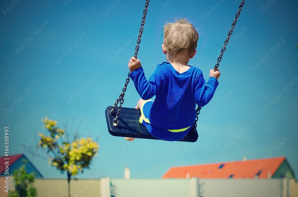 Toddler swinging over the roofs of the houses. Retro colors. Child concept.