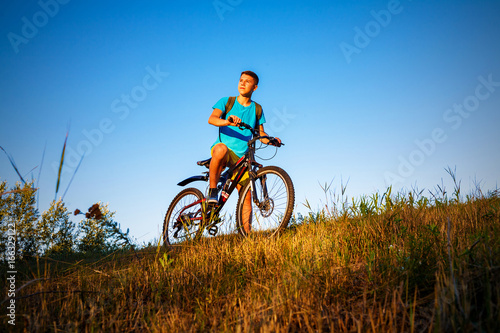 The boy on bicycle and sunset.