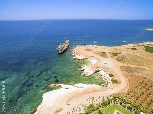 Aerial view of abandoned ship wreck EDRO III in Pegeia, Paphos, Cyprus. The rusty shipwreck is stranded on Peyia rocks at kantarkastoi sea caves, Coral Bay, Pafos, standing at an angle near the shore. photo