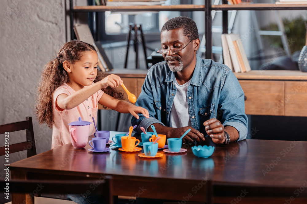 girl having tea party with father