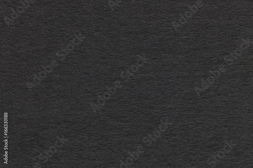 Texture of old gray paper closeup. Structure of a dense cardboard. The black background.