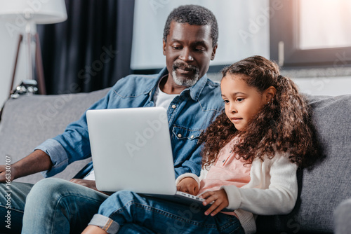Father with daughter using laptop