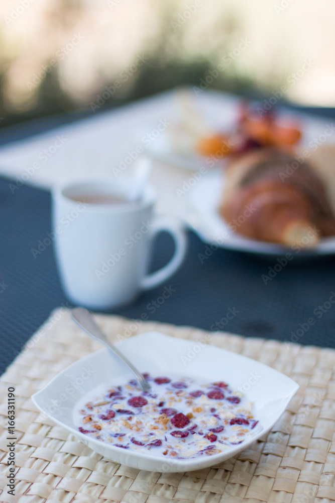 Frühstück mit Müsli, Kaffee und Croissant am Morgen