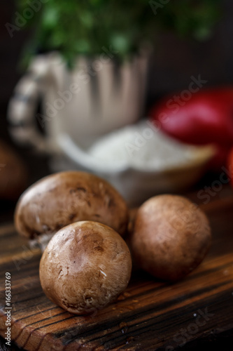 Raw mushrooms on wooden board. Three mushrooms on kitchen.