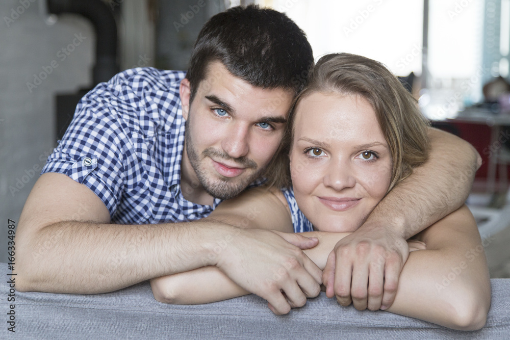 Portrait of smiling young couple at sofa in the living room Portrait of smiling young couple at sofa in the living room