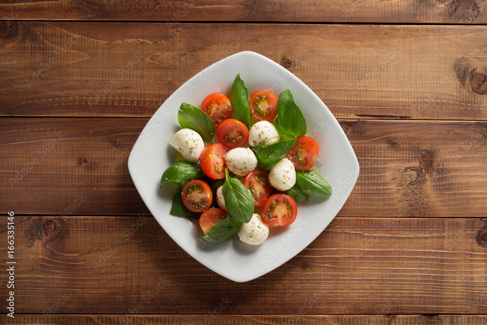 caprese salad in plate at wood caprese salad in plate at wood