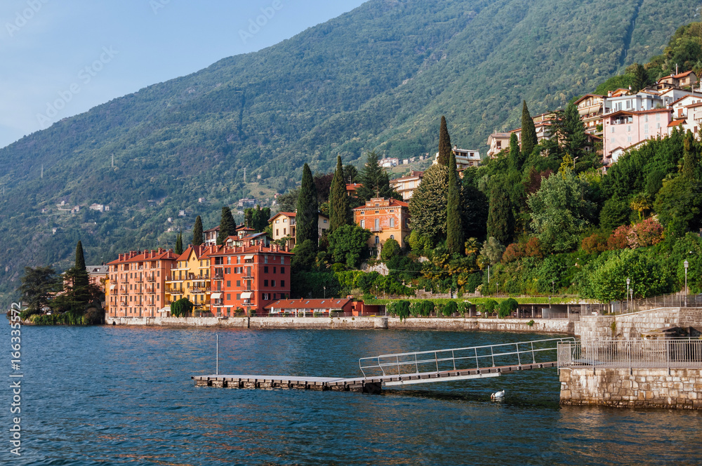  Coastline of Bellano fishing village, situated on Como Lake shore, Lombardy, Italy. Traditional italian houses, mountains and pier in small coast town Bellano.