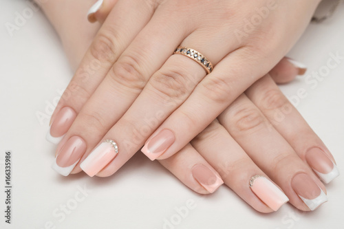 Manicure - Beauty treatment photo of nice manicured woman fingernails. Very nice feminine nail art with nice pink  gold and black nail polish.