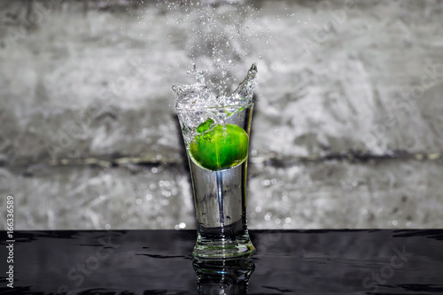 Throw lime into a glass of water, splashing water over glass.