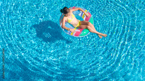 Aerial view of girl in swimming pool from above, kid swim on inflatable ring donut and has fun in water on family vacation   © Iuliia Sokolovska
