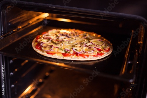 Pizza baking in the oven (close)