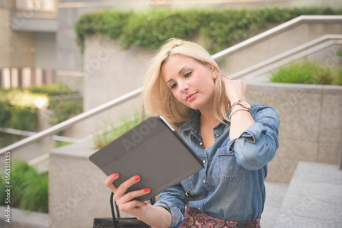 Young beautiful caucasian blonde girl in the city