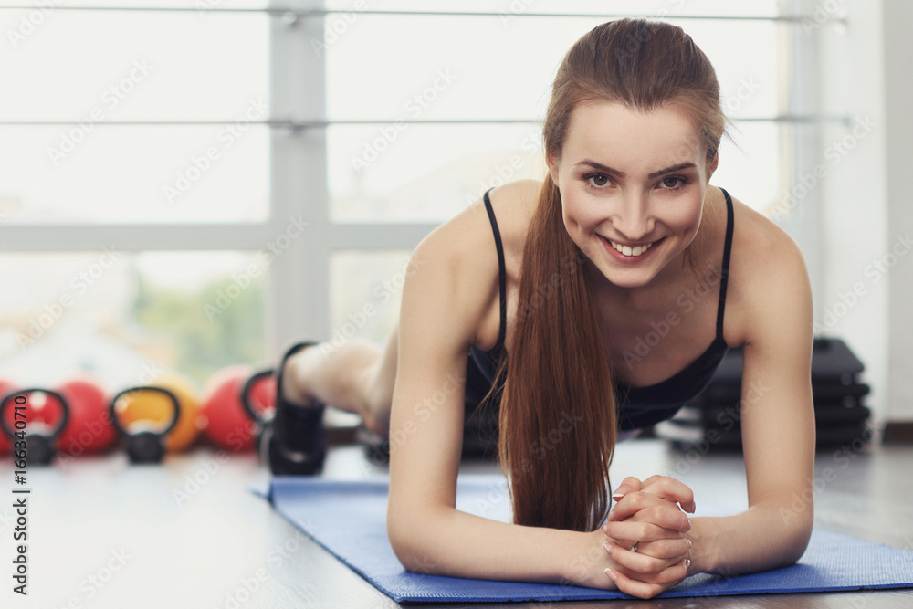 Young smiling woman doing plank exercise Young smiling woman doing plank exercise