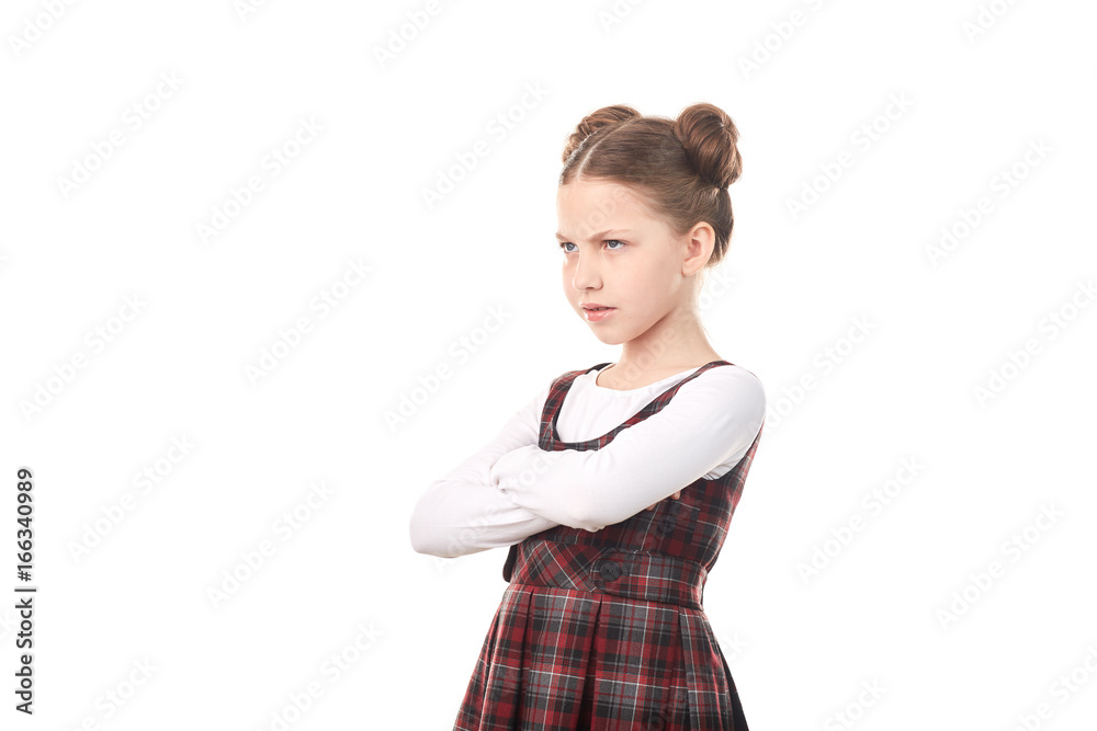 Portrait of offended girl in school uniform standing cross-armed against white background Portrait of offended girl in school uniform standing cross-armed against white background