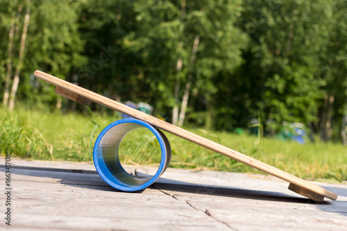 Balance board in on a blue pipe against a background of green forest