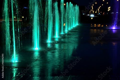 City fountain warm summer night and colorful illuminations