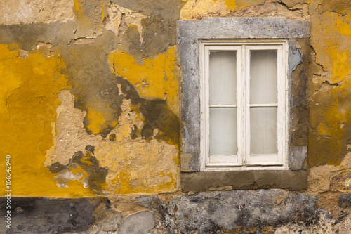 White window on yellow wall