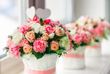 Flower arrangement of white, pink and peach roses at the windowsill. Wedding ceremony