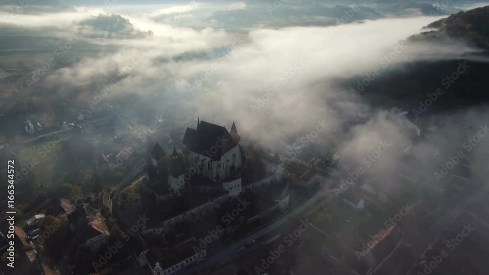 4k drone slow shot over medieval church in Biertan village.Transylvania, Romania.	Countryside view with Biertan fortified church in foreground and mountains in background.
