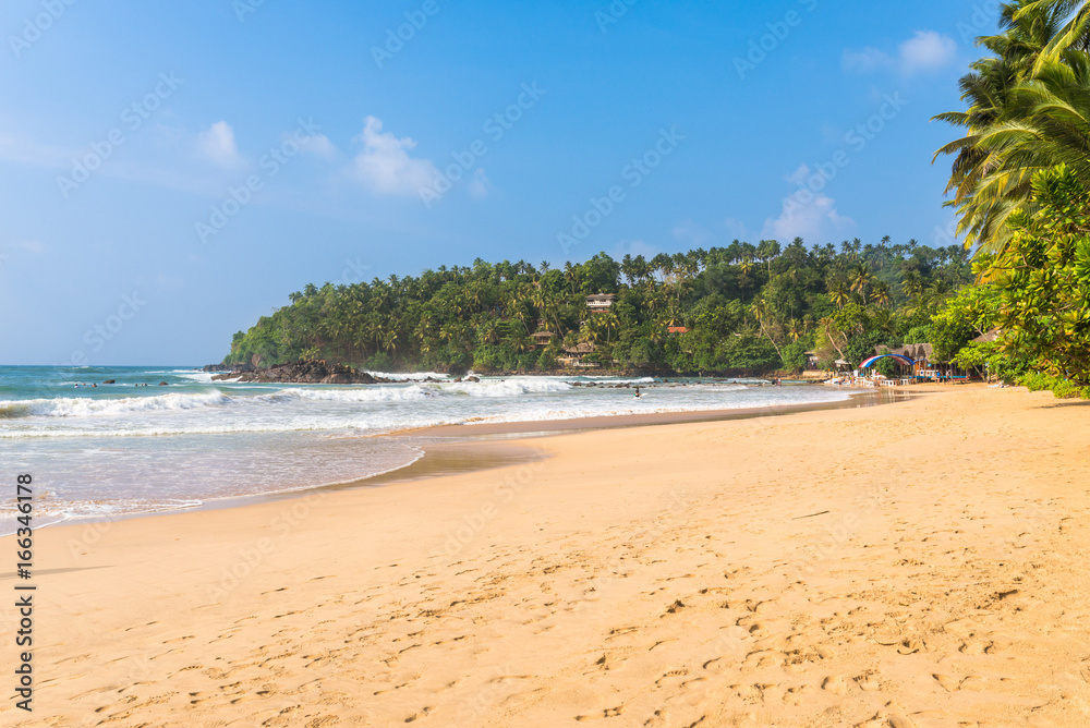 The white sandy beach and bay of Mirissa. The beach at the south coast is very popular among surfer. It is also a fishing port and one of the islands main whale- and dolphin watching locations