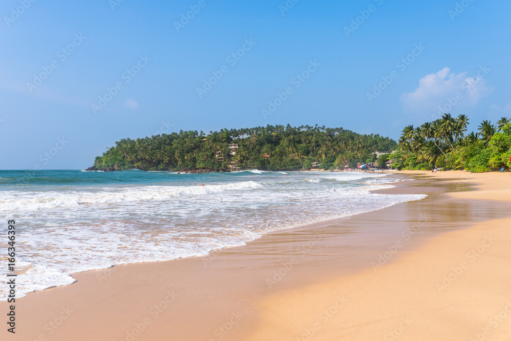 The white sandy beach and bay of Mirissa. The beach at the south coast is very popular among surfer. It is also a fishing port and one of the islands main whale- and dolphin watching locations