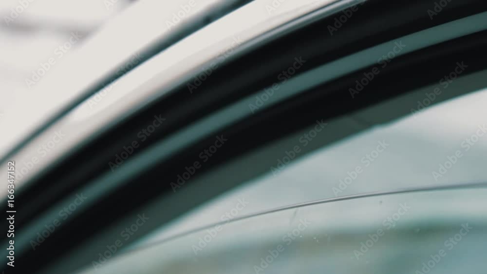 Male hand gives SD memory card to woman driver trough slightly open car window outdoors on cold winter day, close up Male hand gives SD memory card to woman driver trough slightly open car window outdoors on cold winter day, close up