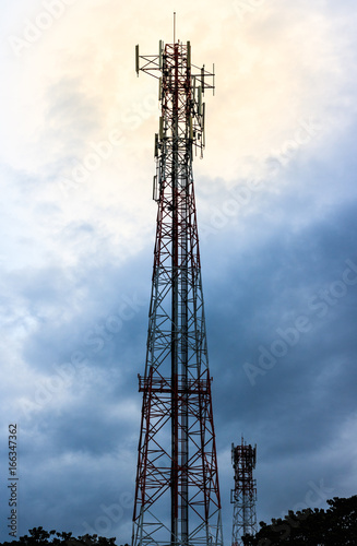 Communication tower with blue sky and cloud.