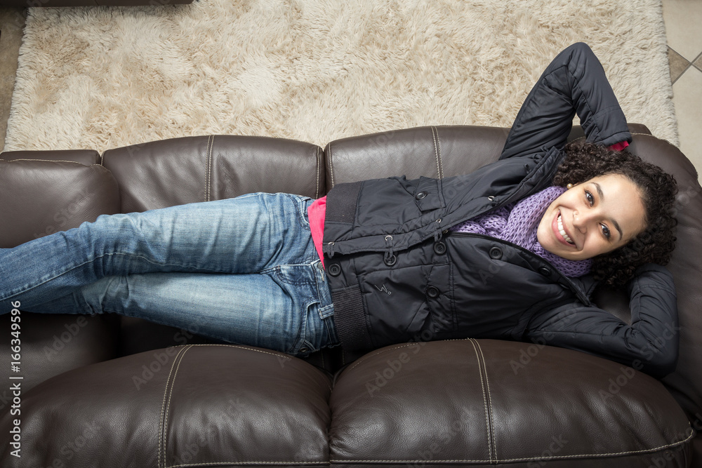 Fototapeta premium Young woman relaxing on couch. Top view.