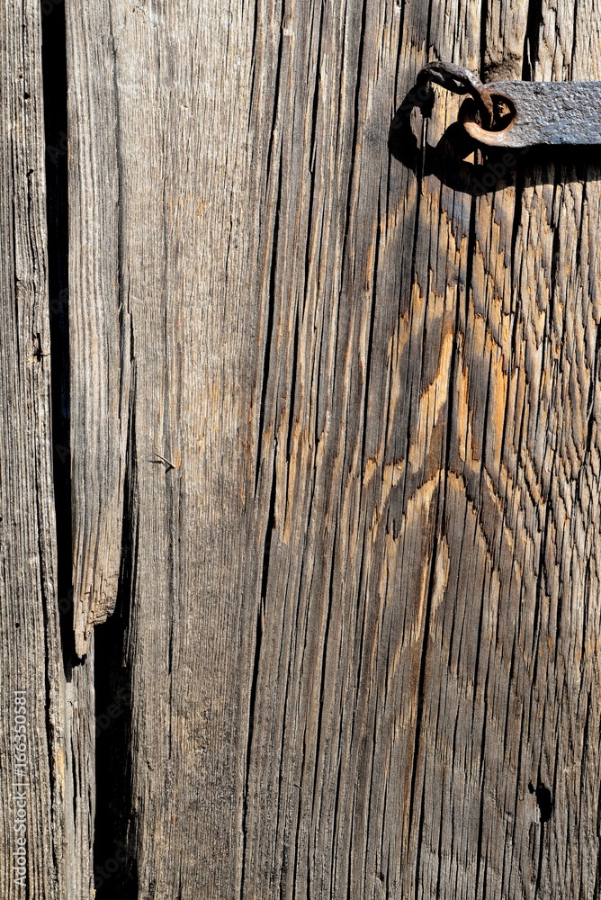 A fragment of an old wooden door closed on a steel skeleton