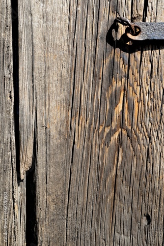 A fragment of an old wooden door closed on a steel skeleton