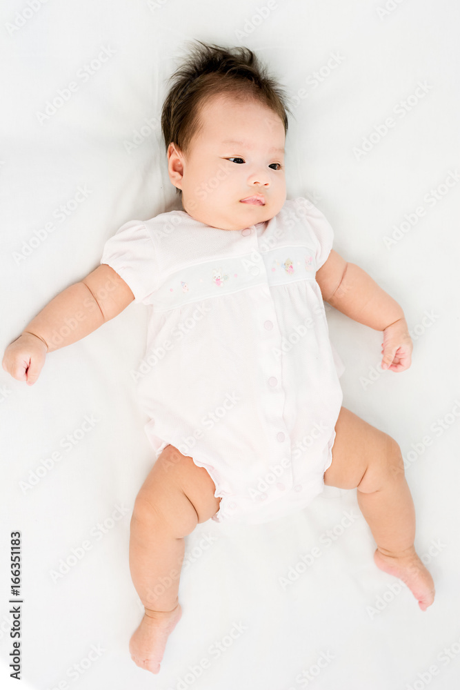 Portrait of a little adorable infant baby girl lying on back on the blanket Portrait of a little adorable infant baby girl lying on back on the blanket