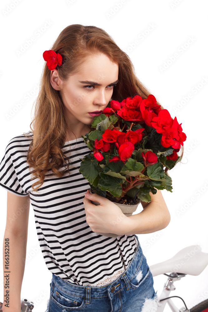 Model smelling flowers while posing with bicycle Model smelling flowers while posing with bicycle