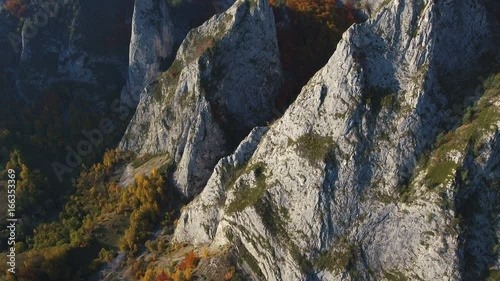 Aerial drone slow shot of deep valley in apuseni, Mountains, Romania.	Close view of limestone cliffs in Scarita Belioara Nature Reserve. 4k footage. photo