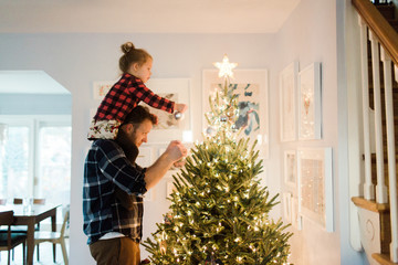 Father and daughter decorate a Christmas tree