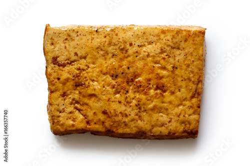Fotografia Single block of marinated tofu isolated on white from above.