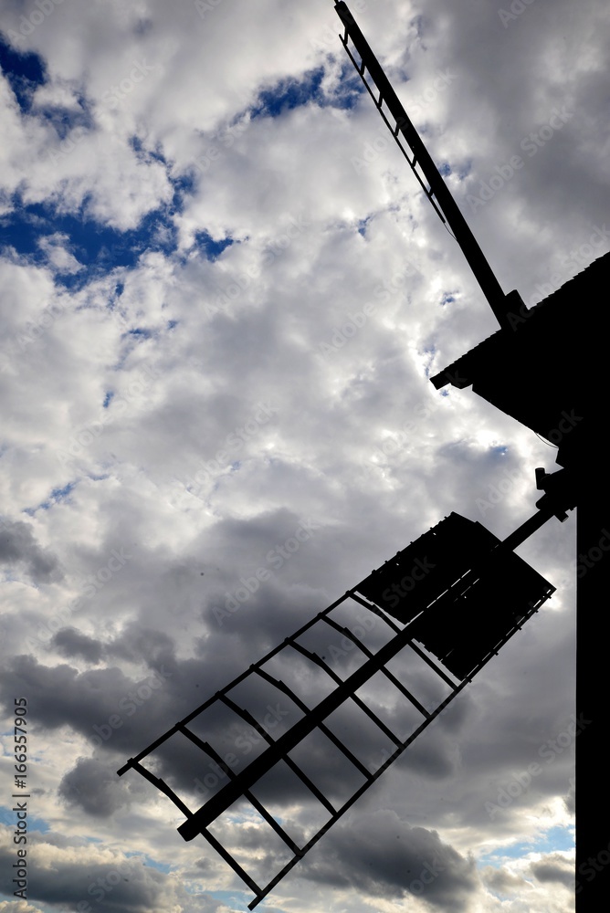 Wing of cereal mill against sky with clouds