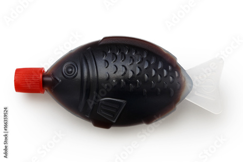 Photography Fish shaped take away soya sauce isolated on white from above.