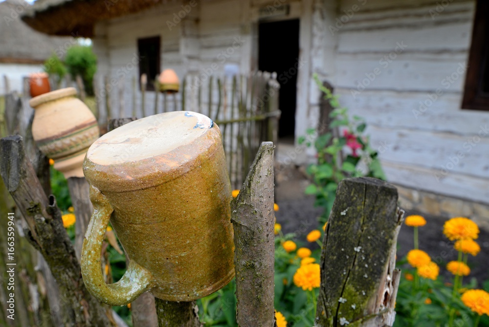 Clay pots drying on a rustic wooden fence