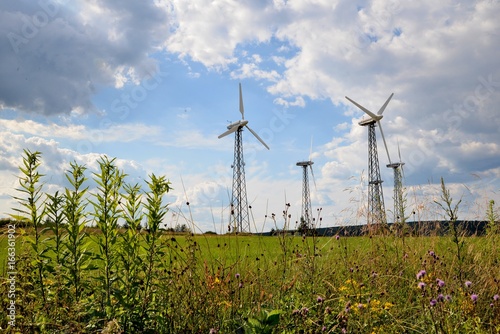 Obraz na płótnie A wind farm or windmills producing energy against the sky w salonie