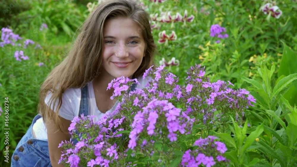 Girl Smelling Perennial Flowers in Garden Girl Smelling Perennial Flowers in Garden