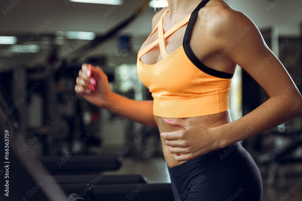 athletic blond woman running on treadmill at gym. athletic blond woman running on treadmill at gym.