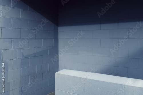 Painted blue cinderblock wall with shadow