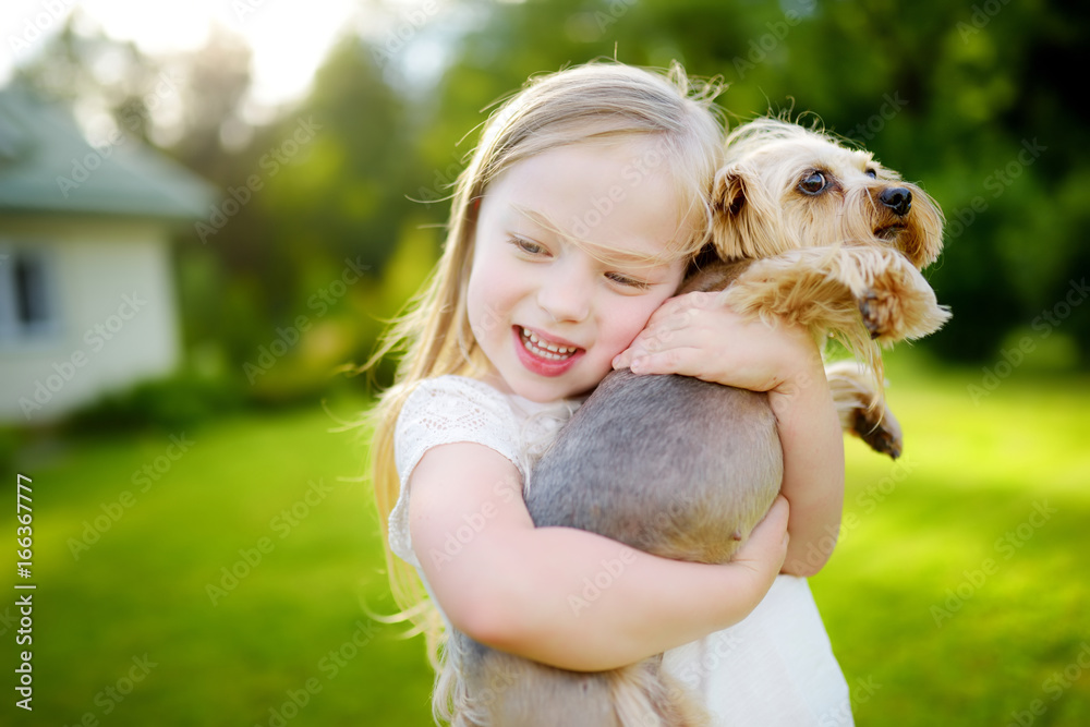 Cute little girl holding her funny yorkshire terrier dog Cute little girl holding her funny yorkshire terrier dog