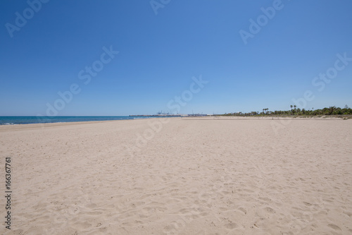 landscape beach in Grao of Castellon  named PIne or Pinar  in Valencia  Spain  Europe. Blue clear sky  Mediterranean Sea and harbour in the horizon  