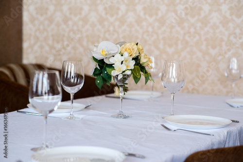 Dining table setting decorated with flowers.