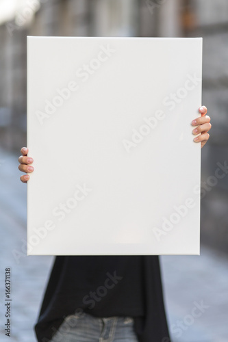 Girl holds a frame for a poster presentation