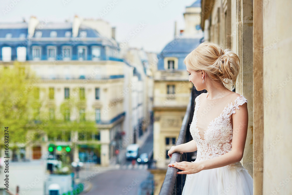 Beautiful young bride on the balcony of her home or hotel room