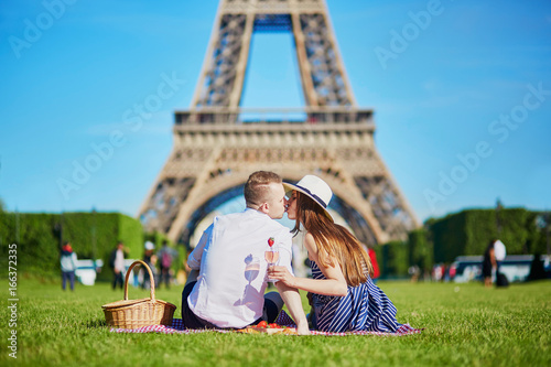 Canvas Print Couple having picnic near the Eiffel tower in Paris, France