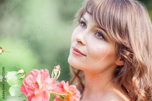 Young beautiful woman walks in flowery Park. Portrait of a young woman. Happy girl. Summer. photo
