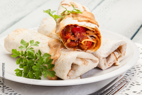 Mexican burritos wraps with mincemeat, beans and vegetables